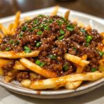A Korean-style ground beef dish featuring tender and flavorful ground beef covered in a glaze, served with French fries.