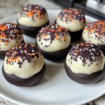Halloween Oreo Balls, featuring a close-up of chocolate-dipped Oreo balls on a clean white plate