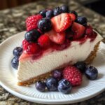 No-Bake Berry Cheesecake, featuring a close-up slice showing its creamy vanilla filling on a crumbly biscuit base