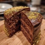 chocolate champagne cake with soft layers and golden sprinkles, displaying a perfectly cut slice to highlight the moist